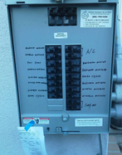 This image shows an electrical panel or distribution board with multiple circuit breakers arranged in rows, with labels indicating different electrical circuits or areas being controlled.